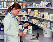 A pharmacist measuring out pills
