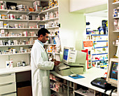 Pharmacist using a computer in a pharmacy