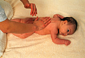 Hand carry out physiotherapy on baby girl's back