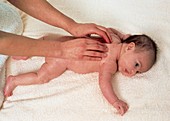 Hands of therapist massaging back of a baby girl
