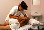 Osteopath treating a man for back pain