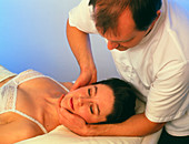 Osteopath treating the neck of a patient
