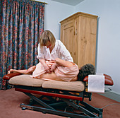 Chiropractor manipulates spine of woman patient