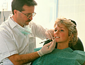 Dentist examines teeth of a female patient