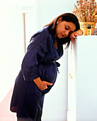 Pregnant woman resting on furniture at home