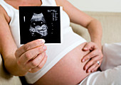 Pregnant woman holding ultrasound scan