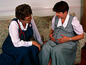 Midwife talking to pregnant woman on home visit