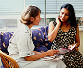 Midwife talks to a pregnant woman on a home visit