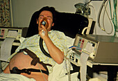 Pregnant woman in labour using oxygen mask
