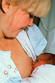 Mother breast-feeding her newborn baby girl