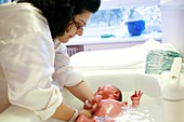 Newborn baby being bathed