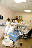 Nurses cleaning an incubator