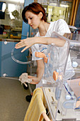 Nurse cleaning an incubator