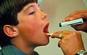 GP examining a young boy's throat