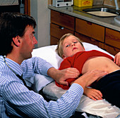 Doctor examining boy's for appendicitis