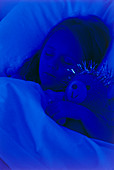 Young girl asleep in bed with teddy bear