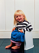A constipated young girl using a potty