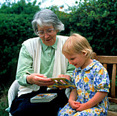 Grandmother reads to her young granddaughter