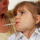 Young girl with fever has oral temperature taken