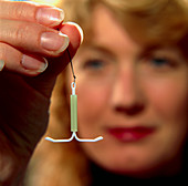 Woman holding intrauterine contraceptive device