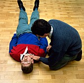 Trainee first aider checks pulse of volunteer