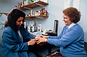 GP examining a patient's hand for arthritis