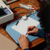 Doctor signing a computer-printed prescription