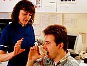 Nurse instructing man in using inhaler