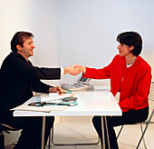 GP doctor shakes the hand of a woman patient