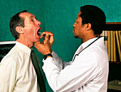 GP doctor examining a man's throat