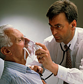 Doctor holds oxygen mask up to elderly man's face