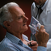 Doctor examines elderly man holding an oxygen mask