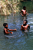 Children standing in bilharzia infected water