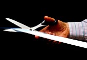 Hand scissors cutting ribbon