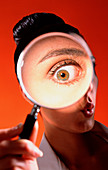 Woman's eye seen through a magnifying glass