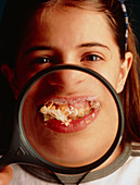 Close-up of girl's mouth stuffed with cake