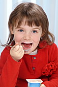 Young girl eating yoghurt
