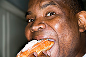 Man eating a creamy finger doughnut