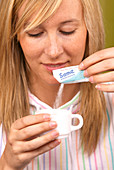 Woman using an artificial sweetener