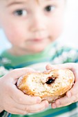Toddler holding a jam doughnut