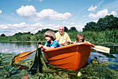 Elderly man and children boating