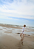 Boy walking on a sandy beach