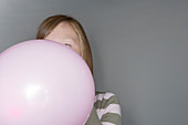 Girl inflating a balloon