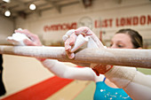 Gymnast rubbing chalk on a bar