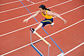 Athlete jumping over a hurdle