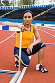 Athlete crouching next to a hurdle