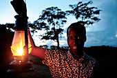 Woman holding a paraffin lamp,Uganda
