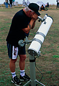 Amateur astronomer using telescope during eclipse