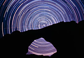 Star trails seen through a stone arch