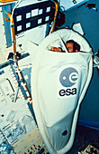Astronaut demonstrating a sleeping restraint